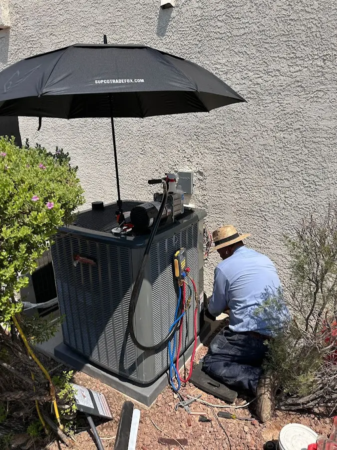 HVAC technician performing outdoor AC maintenance in Wasilla