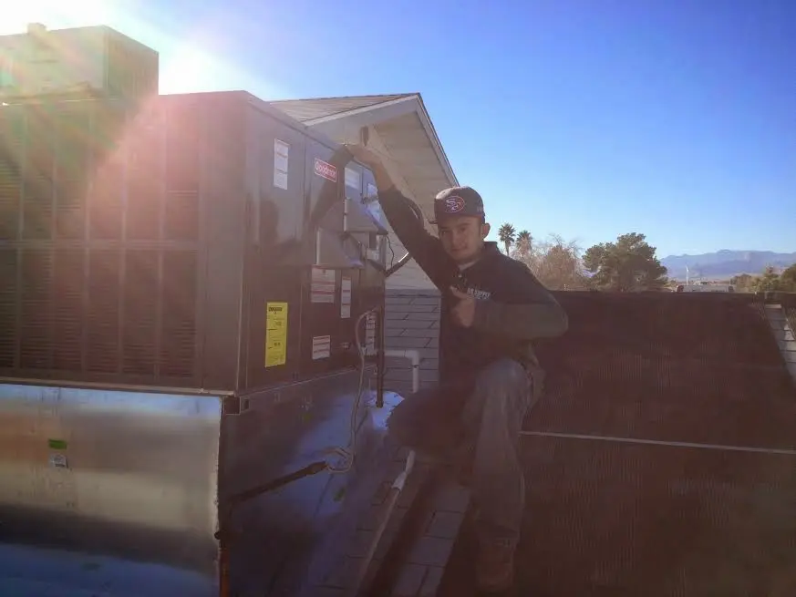 HVAC technician performing HVAC Inspection on a rooftop unit in Wasilla